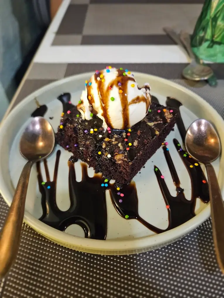 Brownie with ice cream, chocolate sauce and sprinkles at Zaykara